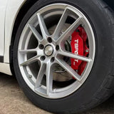 A red TTSPORT 5440 4-piston big brake kit is installed on the 15" front wheel.