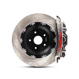 Close-up of a chrome TTSPORT EMB6 6-piston monoblock brake caliper for the front wheel and a slotted 2-piece floating rotor.