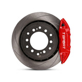 Close-up of a red TTSPORT Toyota LC150 Prado 4-piston forged brake caliper for the rear wheel and a slotted 2-piece rotor.